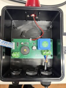 Internal electronics: circuit board with green terminal blocks, blue relay, buzzer, and red/black wires inside a plastic enclosure